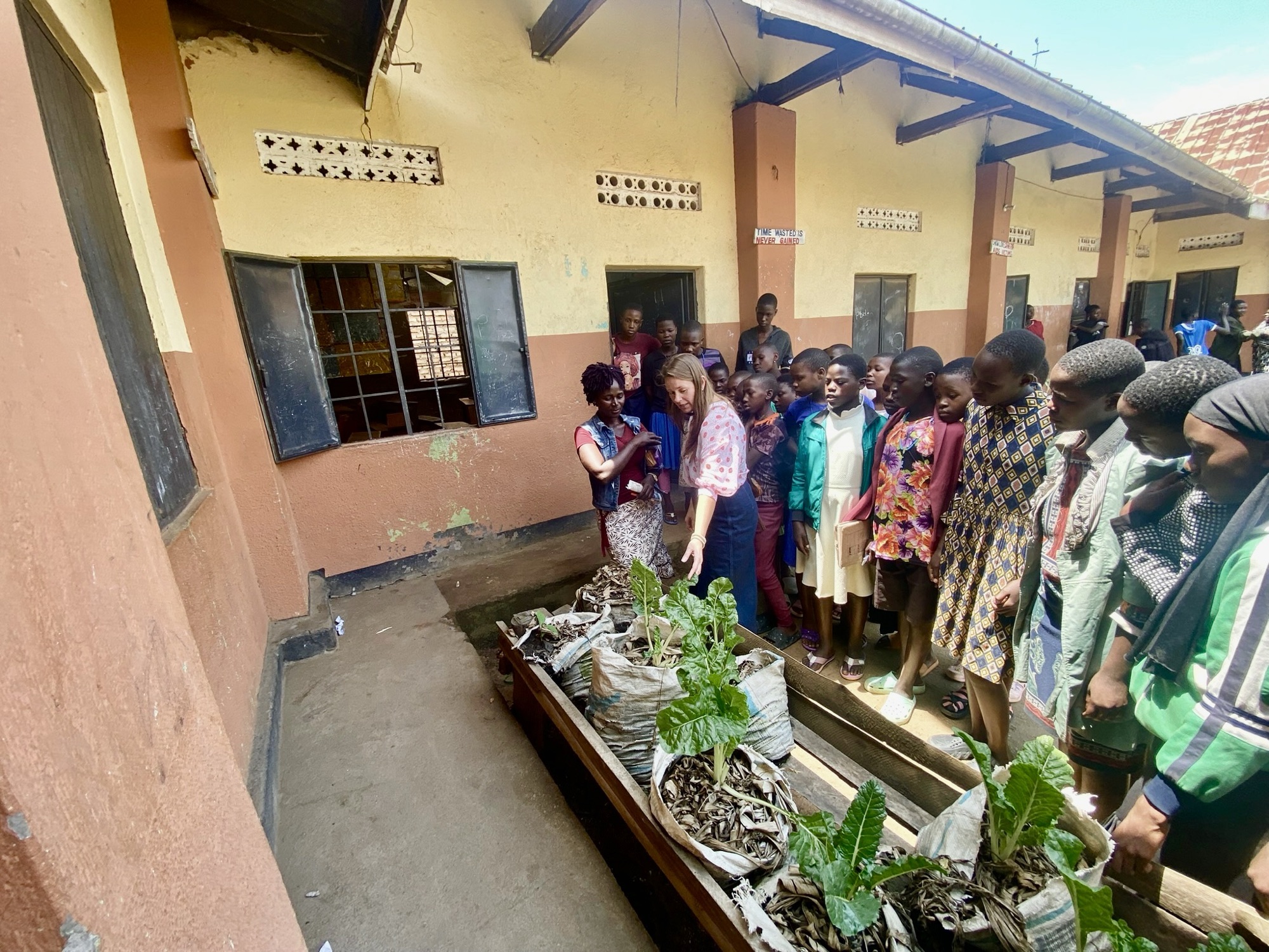 Students around raised sack gardens during a permaculture lesson